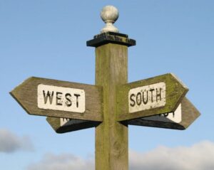 A wooden pole with two signs on it
